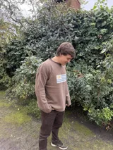 Sweater gris de lana con cuello alto y diseño de la bandera de Uruguay tejida en el frente. Corte clásico y mangas largas.