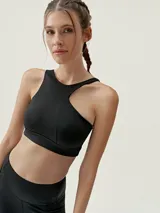 Top deportivo color beige con diseño asimétrico y tirante ancho en un hombro.