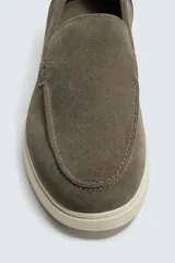 Mocasín casual de hombre, color azul marino, con parte superior de serraje (gamuza) y suela de goma a contraste color beige. Presenta un detalle de bordón cosido en la pala.