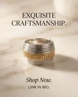 Anillo de acero quirúrgico de diseño ancho y abombado, que combina bandas plateadas lisas con una franja central dorada de textura granulada.