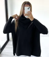 Polerón negro de corte oversize con cuello caído y mangas largas con puños acanalados.