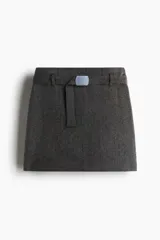 Pollera mini de tiro alto en color gris jaspeado, con diseño estructurado y cinturón extraíble con hebilla metálica rectangular.