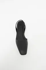 Zapato destalonado de cuero color negro, con punta cuadrada y diseño minimalista.