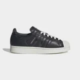 Championes Adidas Superstar II de color negro con la icónica puntera de caucho en relieve y suela blanca. Presenta detalles con estampado de piel de serpiente en las tres tiras laterales y en el talón, además de cordones blancos y el nombre del modelo en dorado.