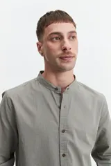 Camisa de hombre color gris con cuello mao, mangas largas y cierre abotonado. Confeccionada en algodón con look lino.