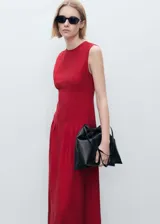 Vestido midi de corte evasé en color rojo, con cuello redondo, sin mangas y tirantes anchos. Presenta un diseño con pinzas en la cintura y cierre posterior con cremallera y botón.