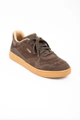Zapatilla urbana de gamuza color marrón, con cordones al tono, suela de goma color caramelo y logo de la marca grabado en el lateral.