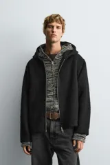 Sobrecamisa de corte relajado confeccionada en tejido con textura efecto pelo. Presenta cuello con capucha, manga larga, bolsillos laterales y cierre frontal con cremallera.