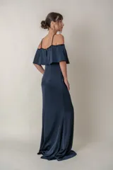 Vestido largo azul marino de crepe de seda, con breteles finos y escote off-shoulder con volado. Presenta bordes bordados en el escote y breteles.