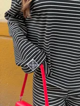 Conjunto de dos piezas de viscosa rayada en color azul marino y blanco, compuesto por un buzo de manga larga de corte holgado y un pantalón ancho tipo palazzo con cintura elástica.