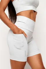 Short tipo biker de tiro alto, diseñado para running y entrenamiento. Confeccionado en tejido técnico de alta performance con bolsillos laterales funcionales y bolsillo interno en la cintura. Presenta detalles reflectivos y costuras estratégicas para mayor libertad de movimiento.