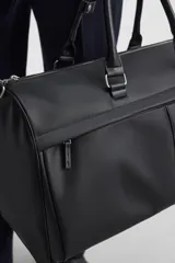 Bolso de viaje negro con textura grabada, compartimento principal con cierre de cremallera, bolsillo interior con cremallera, bolsillo frontal con cremallera y asa de hombro removible y ajustable.