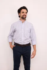 Camisa de corte clásico confeccionada en 100% algodón, con estampado a cuadros en tonos celeste, rosa y azul. Presenta cuello camisero abotonado, cierre frontal con botones, mangas largas y un bolsillo aplicado en el pecho.
