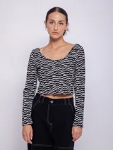 Top de tejido de punto con estampado geométrico en blanco y negro, de manga larga y cuello redondo.