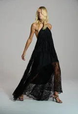 Vestido largo de encaje color negro, con escote halter y diseño asimétrico con transparencias.
