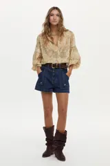 Blusa estampada con diseño paisley en tonos beige y amarillo, con mangas abullonadas de tres cuartos y escote en V profundo.