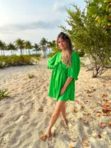 Vestido corto verde manzana de lino, con escote en V con volados y mangas abullonadas.