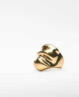 Anillo de metal dorado con diseño orgánico y voluminoso. Presenta logo grabado en el interior.