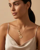 Collar de plata 925 con baño de oro, compuesto por una cadena fina y cuatro dijes circulares de distintos tamaños con diseño de ojo turco y detalles en circonia.
