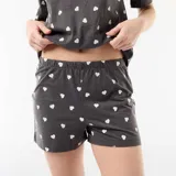 Conjunto de pijama de algodón gris oscuro con estampado de pequeños corazones blancos, compuesto por una remera de manga corta con cuello redondo y un short con elástico en la cintura.