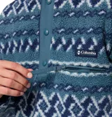 Buzo de polar Columbia con diseño estampado geométrico en tonos azules. Presenta cuello alto con cierre frontal de botones a presión, bolsillo lateral con cierre en el pecho y logo de la marca bordado.
