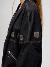 Campera bomber de jean color beige con cierre metálico y apliques bordados.