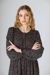 Vestido midi negro con corte en la cintura y falda amplia con volados.