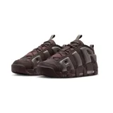 Championes Nike Air More Uptempo Low en color negro con detalles en suela de goma color caramelo. Presentan el icónico diseño de letras grandes en los laterales, confeccionados en una combinación de malla y cuero sintético, con unidad de aire visible en la entresuela.