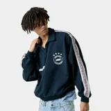 Polo de manga larga color azul marino con cuello clásico, diseño holgado y bandas laterales con estampado en las mangas. Presenta logo bordado en el pecho.