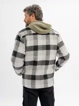 Sobrecamisa de corte recto con estampado de cuadros grandes en tonos gris y negro. Presenta cierre frontal con cremallera, cuello clásico, dos bolsillos frontales con solapa en el pecho y forro interior de sherpa para mayor calidez.