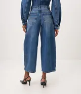Pantalón de jean estilo barrel con tiro alto, recortes laterales sastreros y diseño amplio en las piernas. Confeccionado en algodón con lavado medio.