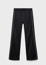 Pantalón de corte recto y tiro medio, color negro con detalle de raya lateral blanca en contraste. Cuenta con cintura elástica y bolsillos laterales.