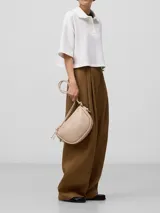 Bandolera color beige con textura craquelada, un compartimento con cierre de cremallera y bolsillo interior con cierre. Asa larga tubular y logo grabado.