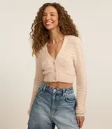 Cardigan cropped color crema con escote en V, manga larga y punto ondulado.