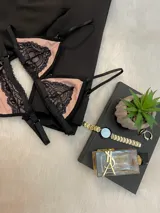 Conjunto de lencería compuesto por un corpiño triangular y una tanga, confeccionados en lycra color beige con detalles de encaje negro y elásticos a tono.