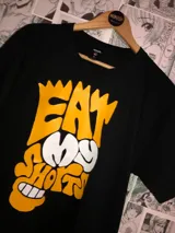 Remera negra de algodón con estampa amarilla y blanca con la frase "Eat my shorts" y la boca de Bart Simpson.