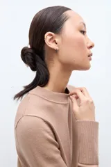 Sweater azul marino de manga larga con cuello redondo, combinado con una camisa celeste que se asoma por debajo.