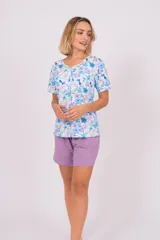 Pijama de dos piezas, compuesto por una remera de manga corta con botones y estampado de flores en tonos celeste, azul y lila, y un short lila con cintura elástica.