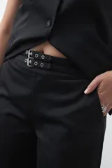 Pantalón wide leg color marrón chocolate, de tiro medio y corte relajado. Presenta detalle de hebillas laterales con ojales metálicos en la cintura y una caída fluida.