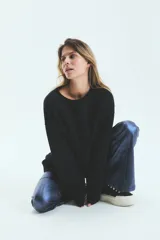 Buzo negro oversize de frisa esmerilada con cuello alto, hombros caídos, bolsillos laterales y estampa en la espalda con el logo de la marca en animal print.