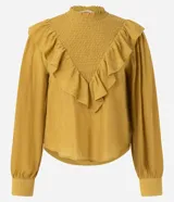 Blusa de manga larga color mostaza con cuello alto y detalle de panel delantero texturizado. Presenta volados aplicados en el busto y puños abotonados.