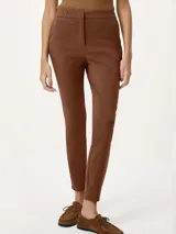 Pantalón sastrero de corte recto y ajuste entallado, con cintura de tiro medio, cierre frontal con botón y bolsillos laterales.