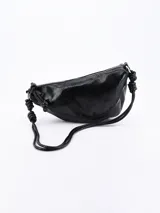 Bandolera negra de cuero sintético con correa de hombro con nudos decorativos. Cierre superior con cremallera.