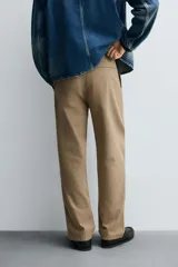 Pantalón chino de corte recto confeccionado en tejido ligero de algodón con estructura canvas. Presenta bolsillos frontales, bolsillos traseros de vivo y cierre frontal con cremallera y botón.