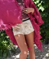 Shorts color crema de lino bordado con diseño floral, cintura alta con botón y volados frontales.