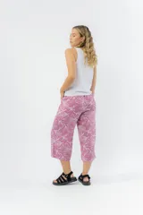 Pantalón de corte culotte y tiro medio, confeccionado en viscosa con estampado de hojas blancas sobre fondo color miel. Presenta una silueta amplia y fluida, con cintura elástica en la parte posterior y bolsillos laterales.