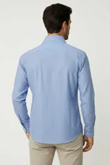 Camisa de algodón de manga larga con diseño de rayas verticales en tonos gris y blanco, cuello camisero clásico y cierre frontal con botones.