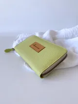 Billetera grande de cuero color verde lima con cierre metálico y monedero interno.