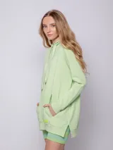 Canguro blanco oversize con capucha, cordones y bolsillo tipo canguro.