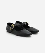 Zapatilla tipo bailarina Satinato de cuero negro, con punta cuadrada, tacón bajo y tira en el empeine con hebilla metálica dorada grande.